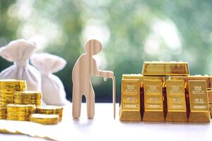 Mutual fund,Seniorman with gold bar and stack of gold coin money on wooder background, Save money for prepare in future and pension retirement concept photo