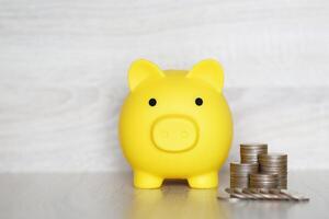 Finance, Piggy bank and coins money on wooden background, Save money for prepare in future and pension retirement concept photo