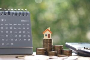 Finance, Model house on stack of coins money on natural green background, Business investment and real estate concept photo