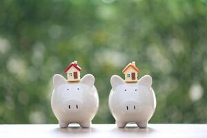 Model house on piggy bank with stack of coins money on nature green background,Business investment and real estate concept photo