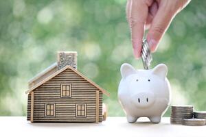 Finance, Model house with piggy bank and stack of coins money on natural green background,Business investment and real estate concept photo