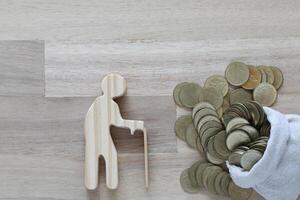 Mutual fund,Senior man and money bag on wooden background, Save money for prepare in future and pension retirement concept photo