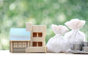 Finance, Model house with money bag on natural green background,Business investment and Save money for prepare in future concept photo