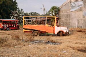 a dilapilated bus with a missing tire on the park photo
