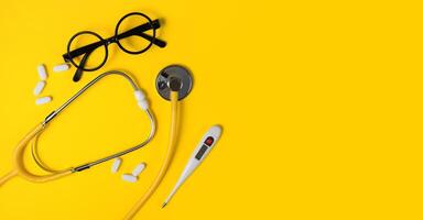 Concept of medicine. Yellow stethoscope on a yellow background. Children's medicines. Medical background. Copy space. photo