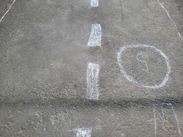 In the courtyard on the asphalt there is a drawing of classics in chalk figures in circles photo