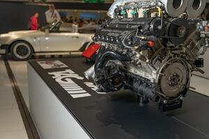 Stuttgart, Germany, August 13, 2023. Car engine part. New engine new car. Car engine on the background of a Porsche car. TAG Turbo. photo