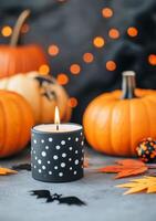 Halloween candle surrounded by decorated pumpkins and autumn leaves photo