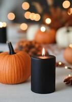 Halloween candle surrounded by decorated pumpkins and autumn leaves photo