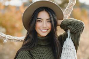 Young woman in a brown sweater and hat poses cheerfully in an autumn park setting photo