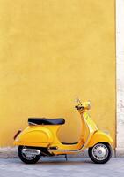 Bright yellow scooter parked against a weathered wall in a charming urban setting photo