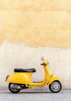 Bright yellow scooter parked against a weathered wall in a charming urban setting photo