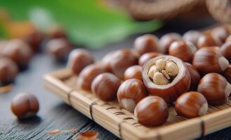 Fresh hazelnuts in a woven basket surrounded by autumn leaves in a sunlit garden photo