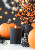 Halloween decorations with black candles, pumpkins, and spooky elements on a grey backdrop photo