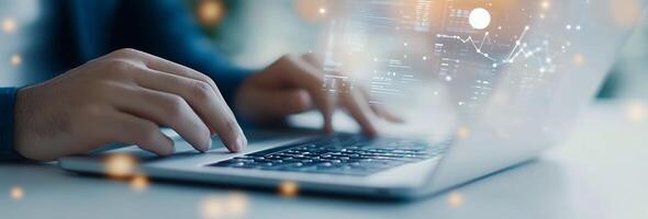 Person typing on a laptop while data visuals appear in a modern workspace photo