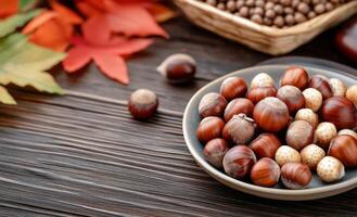 Freshly harvested hazelnuts on a textured wooden table with autumn leaves in the background photo
