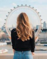 Young woman posing near the London Eye on a sunny day with soft city backdrop photo