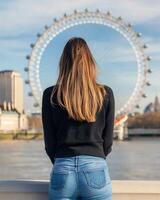 Young woman posing near the London Eye on a sunny day with soft city backdrop photo