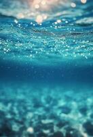 Sunlight sparkles on the surface of clear blue water in a tranquil underwater setting photo