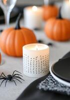 Halloween decorations with black candles, pumpkins, and spooky elements on a grey backdrop photo