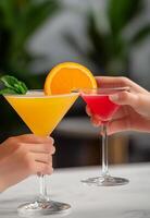 Two friends toasting with colorful cocktails in a trendy bar during the evening photo