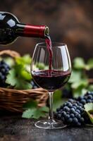 Pouring red wine into a glass beside fresh grapes and autumn leaves photo