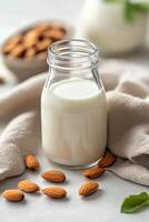 Almond milk in a glass with whole almonds on a cloth napkin photo