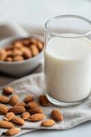 Almond milk in a glass with whole almonds on a cloth napkin photo