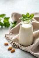 Almond milk in a glass with whole almonds on a cloth napkin photo