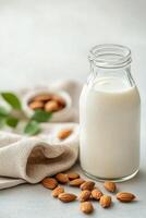 Almond milk in a glass with whole almonds on a cloth napkin photo