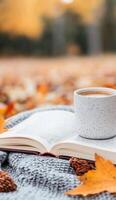 A cozy moment with a book and coffee amid autumn leaves in the park photo