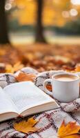 A cozy moment with a book and coffee amid autumn leaves in the park photo