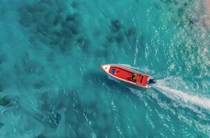 Red Boat Cruising Over Turquoise Waters in a Tropical Paradise photo