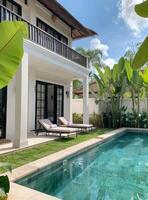 Tranquil Villa Pool Surrounded by Lush Tropical Plants on a Sunny Day photo
