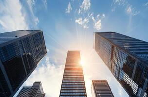 Sunlight Shining Down Between Skyscrapers in Urban Setting photo
