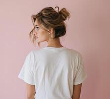 Woman With Wavy Hair Facing Pink Wall in Bright Minimalist Setting photo