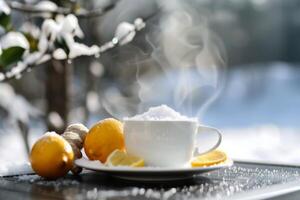 Warm Ginger Tea With Lemon Slices Surrounded by Snow in Winter photo