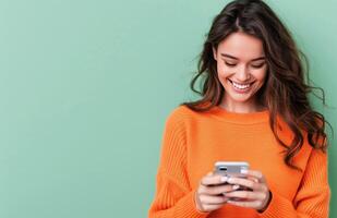 Young Woman Smiling While Texting on Smartphone Against Green Background photo