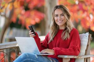 Young Woman Using Laptop and Mobile Phone Outdoors in Autumn photo