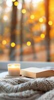 Cozy Bedroom Setting With Candle and Books Surrounded by Autumn Foliage photo
