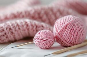 Pink Yarn Ball and Knitting Needles With Soft Knit Fabric photo