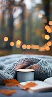Cozy Bedroom Setting With Candle and Books Surrounded by Autumn Foliage photo