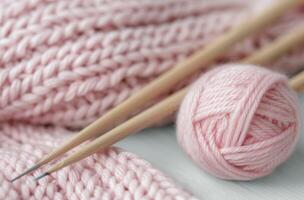 Pink Yarn Ball and Knitting Needles With Soft Knit Fabric photo