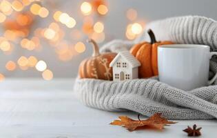 Cozy Autumn Still Life With Pumpkins, a House Model, and a Mug Surrounded by Warm Lights photo