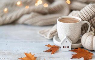 Cozy Autumn Still Life With Pumpkins, a House Model, and a Mug Surrounded by Warm Lights photo