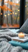Cozy Bedroom Setting With Candle and Books Surrounded by Autumn Foliage photo