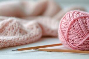Pink Yarn Ball and Knitting Needles With Soft Knit Fabric photo
