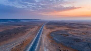 Vast Open Road Through Arid Landscape at Dusk photo