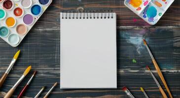 Blank Sketchbook and Watercolor Palette on Wooden Table photo