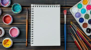 Blank Sketchbook and Watercolor Palette on Wooden Table photo